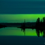A Slice of Aurora: Cloud cover allows a slice of northern lights to shine over Devil Track Lake. Minnesota.