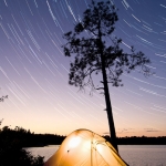 Camping Under the Stars: A tent under startrails in the BWCA. Red Rock Bay on Sag.