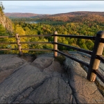 Fall on Oberg: A fence prevents hikers from falling off a cliff. Fall colors on the hills. Lutsen, Minnesota.