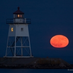 Grand Marais Moonrise: The moon rises next to the Grand Marais lighthouse. Lake Superior, Minnesota.