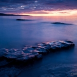 Deep Purple: The sun rises over the basalt shore of Artist's Point. Grand Marais, MN.