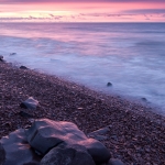 Collecting: Rocks shaped by Lake Superior's wave action collect in basalt depressions created by the same waves. Lake Superior, Minnesota.