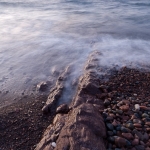 Superior's Finger Bone: A hard dyke of rock extends into Lake Superior. Waves, sunrise.