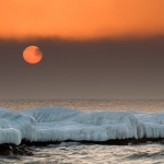 Sun Disk Behind Fog: The sun, veiled behind a thin layer of fog, rises over Lake Superior. Paradise Beach, Minnesota. (110216-46)