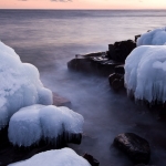 Grand Marais Shoreline at Dusk: Lake Superior waves roll into a rock slot. A long exposure makes the water look like clouds. Grand Marais, Minnesota. 110302-52