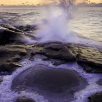 Ice and Wave: Waves crash near a puddle of ice.