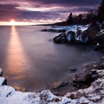 Winter Sunset at Butterwort Cliffs: The sun sets over Lake Superior at Butterwort Cliffs SNA in winter. Minnesota.