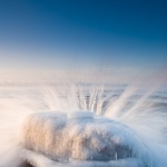 Rock, Ice and Waves: Waves splash over an ice-coated rock on Lake Superior.