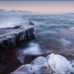 Winter on Artist's Point: Waves wash over rocks and ice on Artist's Point. Grand Marais, MN.