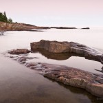 Permalink to The Bones of Earth – Photos from Artist’s Point Grand Marais, MN Water flows and weaves around rocks on Artist's Point at sunset. Grand Marais, MN