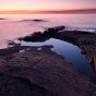 The sunrise reflected in Lake Superior and a still puddle on Artist's Point.