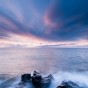 Wisps of clouds light up blue and pink at sunrise near Grand Marais, MN.