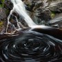 An eddy creates a circular swirl of foam on the Fall River.